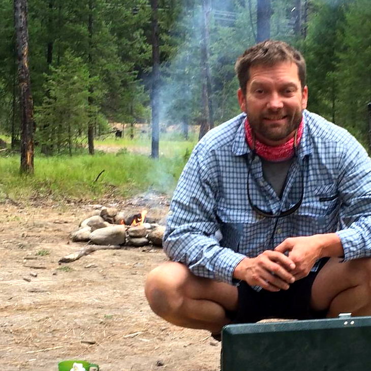 Rob Smith cooking dinner on a camp stove at a forest campsite